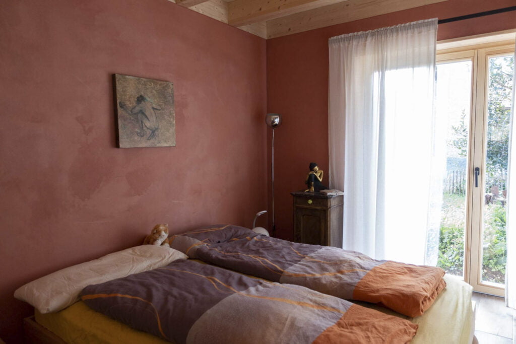 Schlafzimmer ist eingerichtet mit Bett und Lampe, Bild und Nachttischchen
